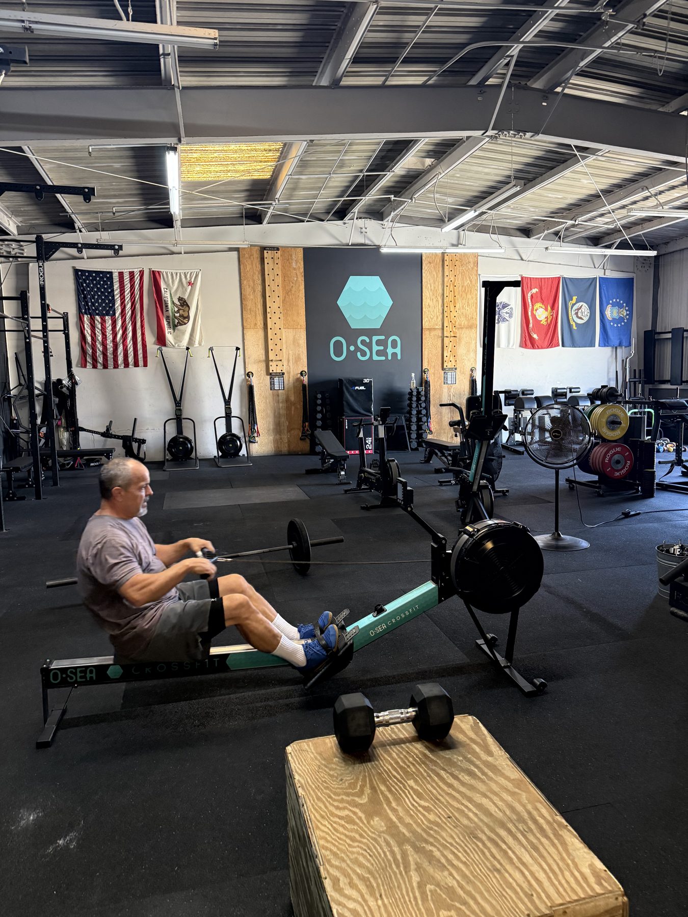 A client rowing inside the O-SEA gym in San Clemente during a personal training session
